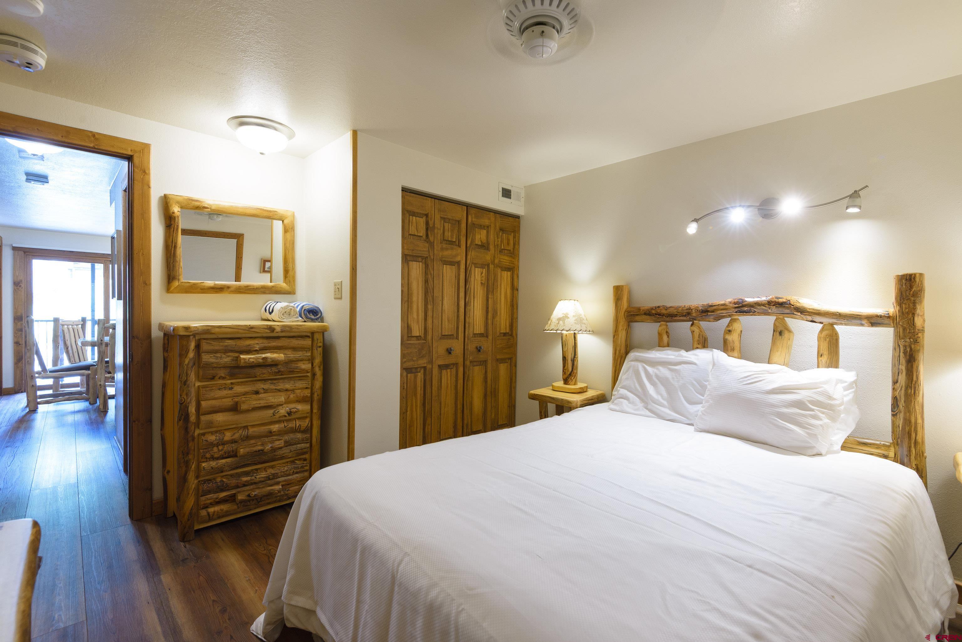 701 Gothic Road, Unit 332 Crested Butte, CO 81225 - Photo 16 of 29 a bedroom with a bed and wooden floor