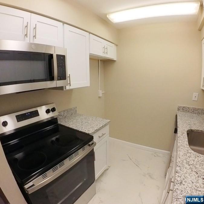 1600 Center Avenue, Unit 1D Fort Lee, NJ 07024 - Photo 5 of 10 a kitchen with a stove and a microwave