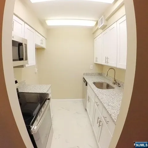 a bathroom with a granite countertop sink and washing machine