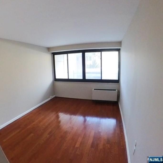 1600 Center Avenue, Unit 1D Fort Lee, NJ 07024 - Photo 9 of 10 an empty room with wooden floor and windows