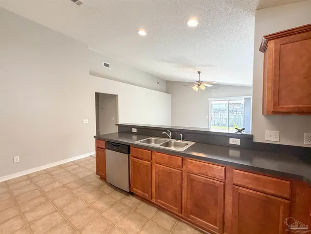 a kitchen with granite countertop a sink and cabinets
