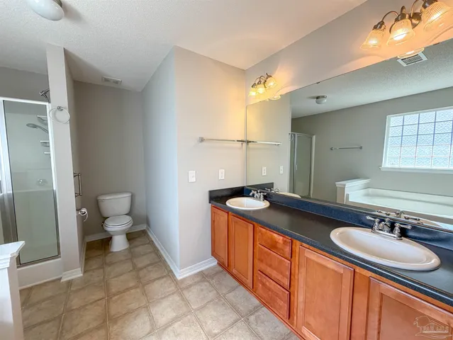a spacious bathroom with a sink double vanity and a toilet