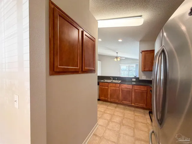 a large kitchen with stainless steel appliances granite countertop a refrigerator and a sink