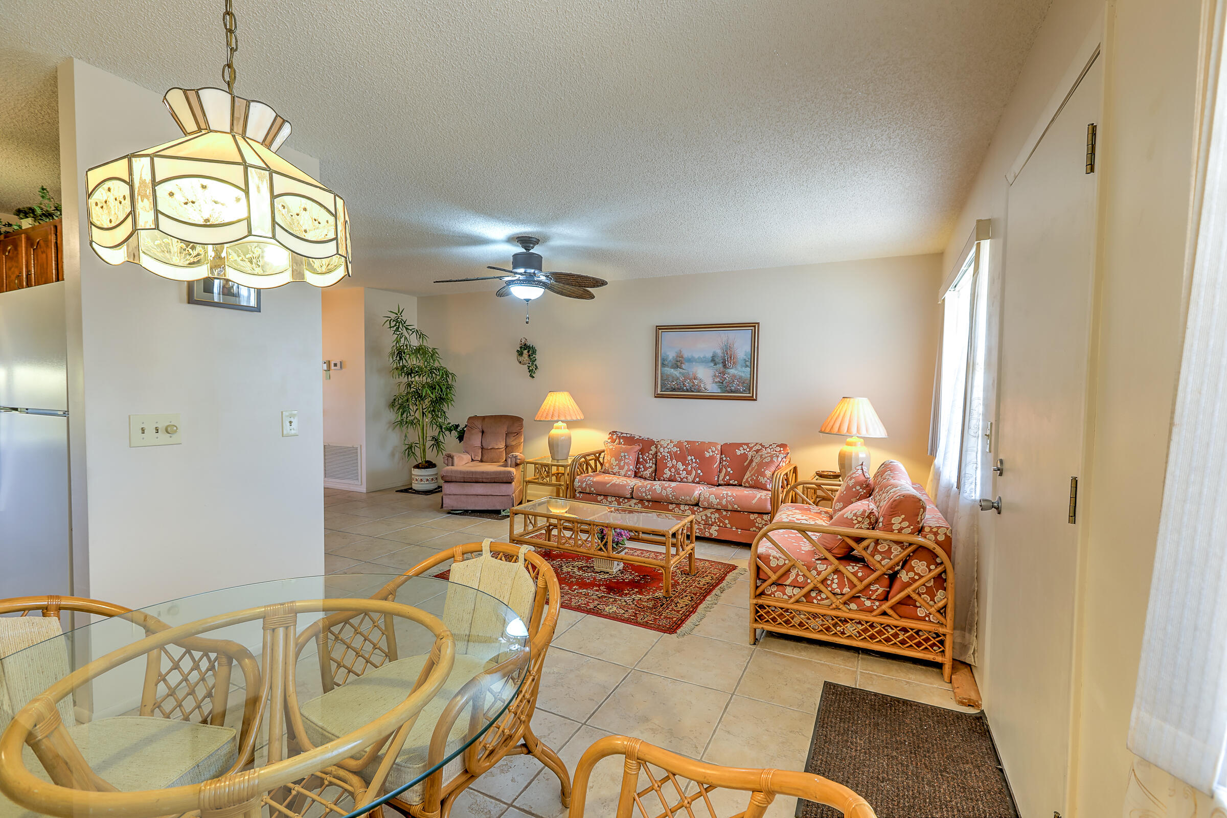 25 Lake Vista Trail, Unit 203 Port St. Lucie, FL 34952 - Photo 11 of 36 a living room with furniture and a chandelier