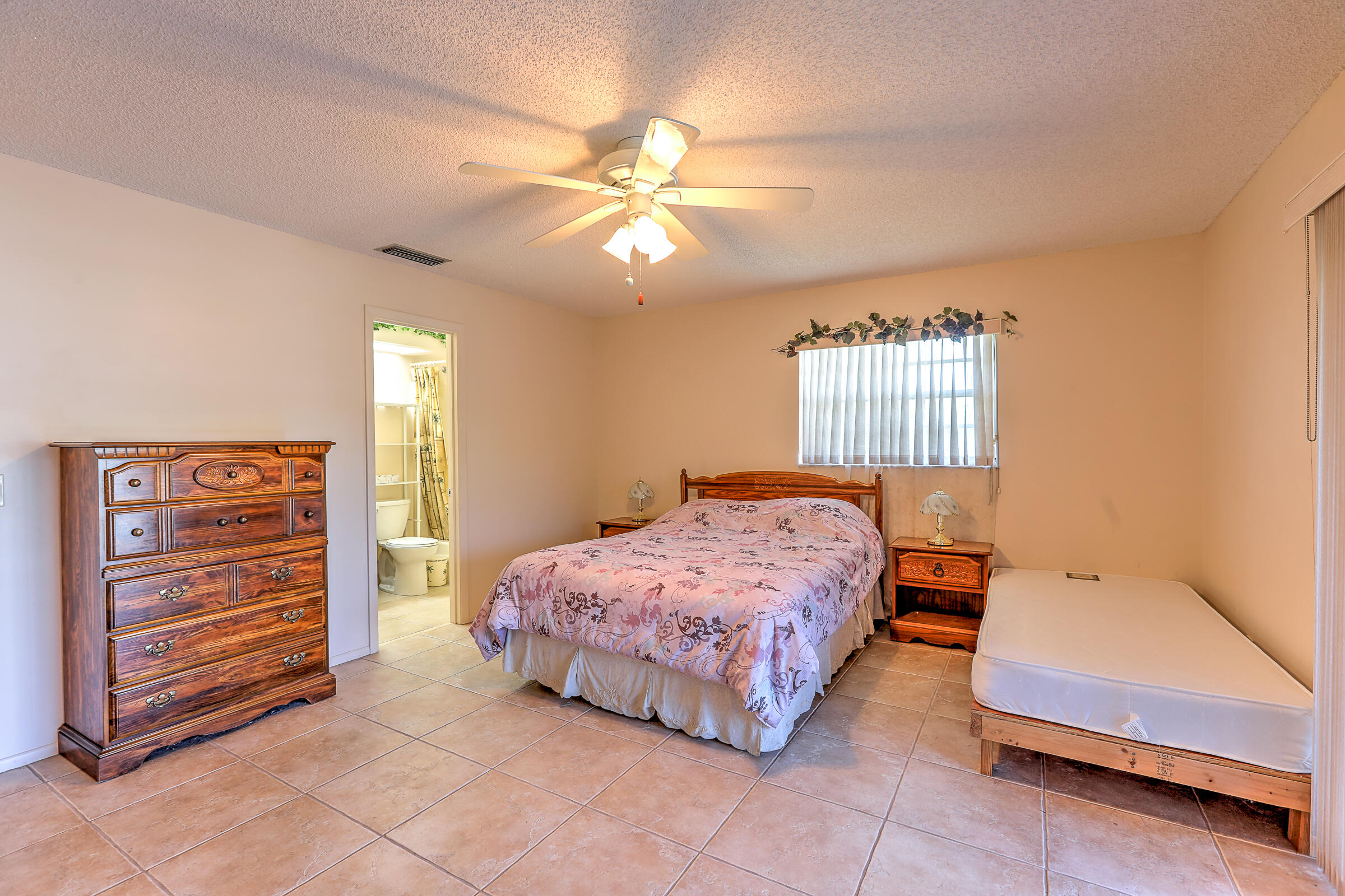 25 Lake Vista Trail, Unit 203 Port St. Lucie, FL 34952 - Photo 16 of 36 a bedroom with a bed and a chandelier