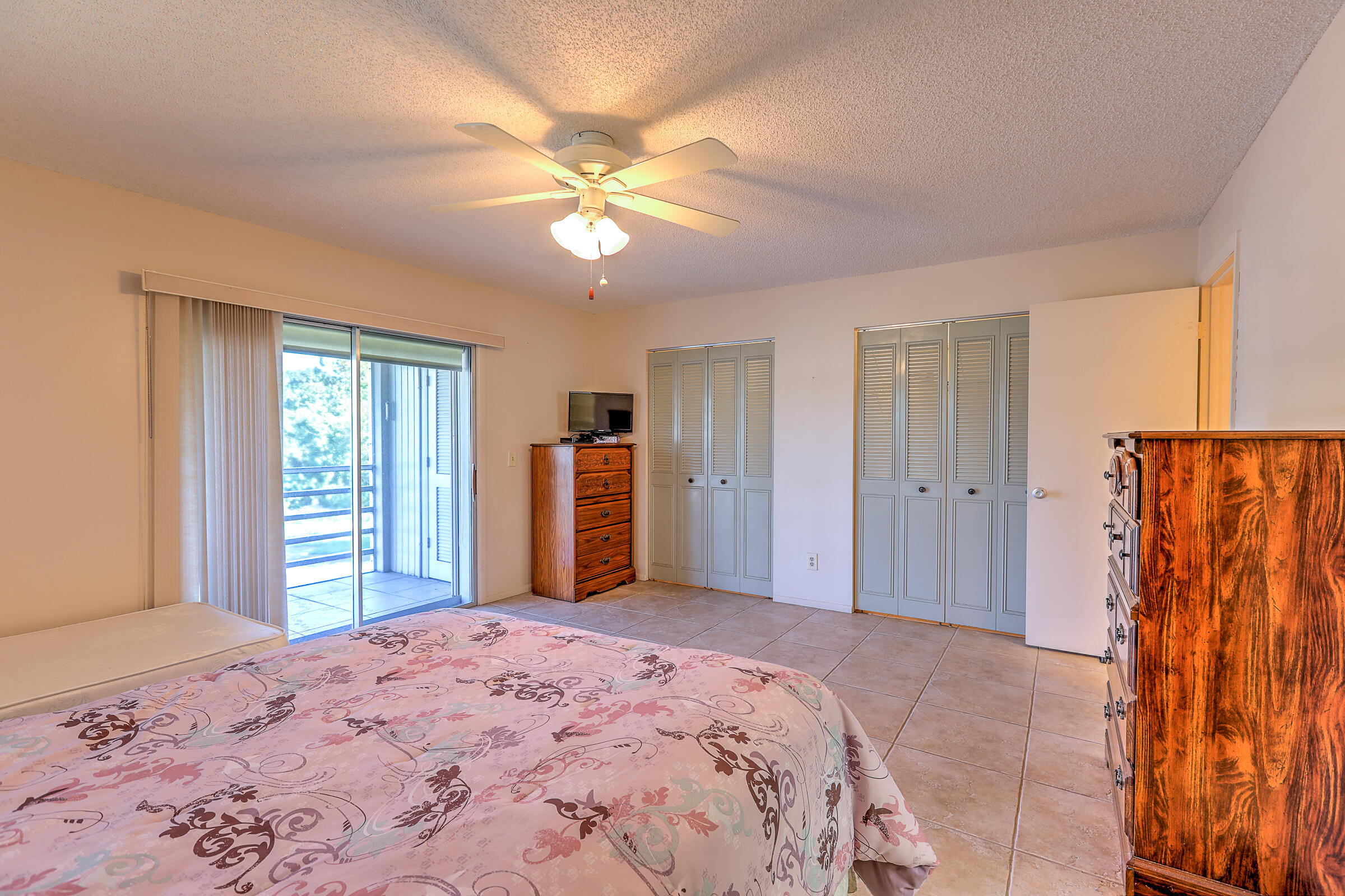 25 Lake Vista Trail, Unit 203 Port St. Lucie, FL 34952 - Photo 17 of 36 a bedroom with a bed and a chandelier