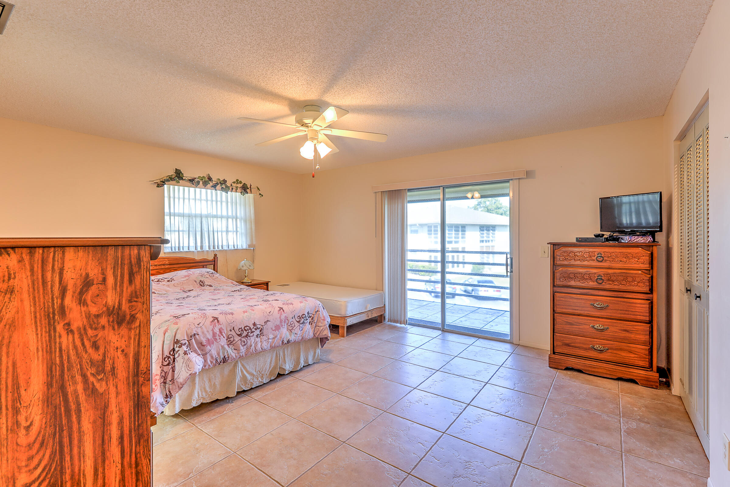 25 Lake Vista Trail, Unit 203 Port St. Lucie, FL 34952 - Photo 18 of 36 a bedroom with a bed and a chandelier