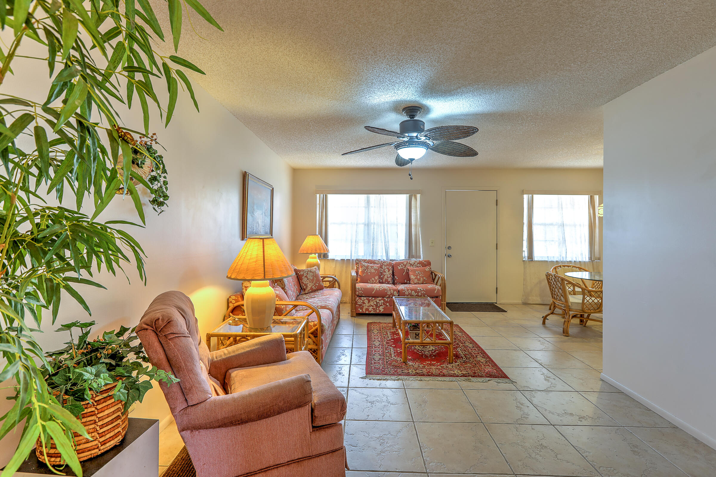 25 Lake Vista Trail, Unit 203 Port St. Lucie, FL 34952 - Photo 8 of 36 a living room with furniture a chandelier and a rug