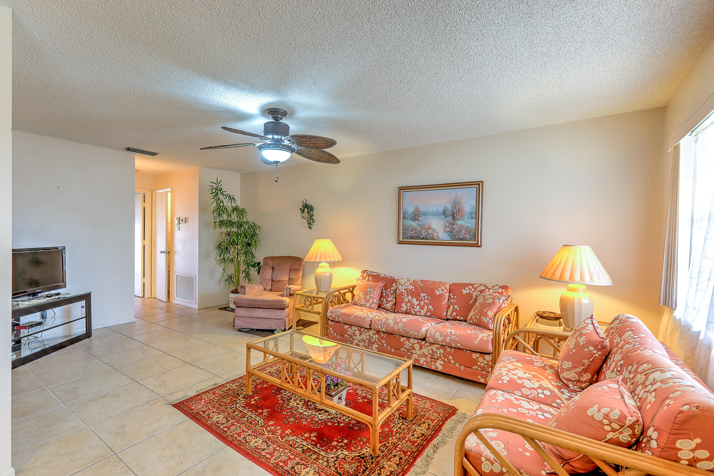 25 Lake Vista Trail, Unit 203 Port St. Lucie, FL 34952 - Photo 9 of 36 a living room with furniture and a flat screen tv