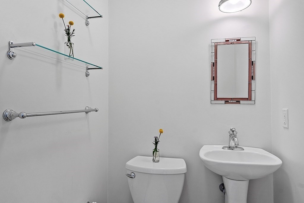 21 Cottage Street Hamilton, MA 01982 - Photo 15 of 40 a bathroom with a sink a mirror and a toilet