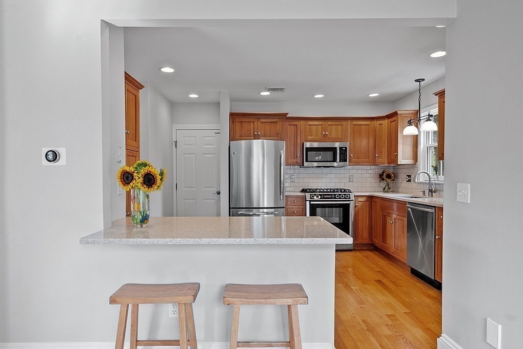 21 Cottage Street Hamilton, MA 01982 - Photo 6 of 40 a kitchen with stainless steel appliances granite countertop a refrigerator and a stove top oven