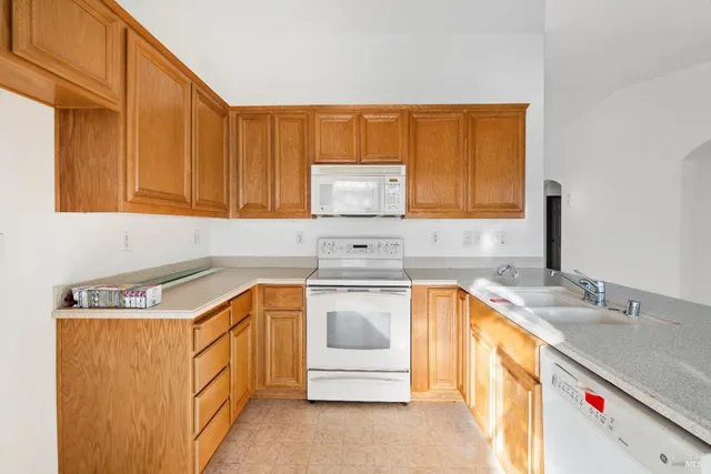 a kitchen with stainless steel appliances granite countertop a sink a stove and a microwave