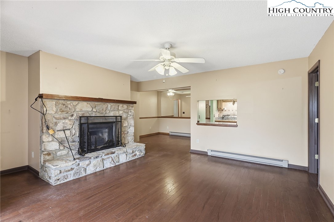155 Glen Burney Road, Unit C4 Blowing Rock, NC 28605 - Photo 2 of 15 a view of a room with wooden floor and a fireplace
