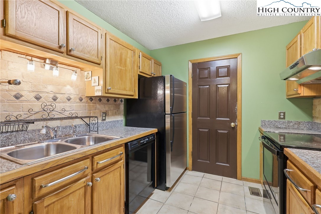 155 Glen Burney Road, Unit C4 Blowing Rock, NC 28605 - Photo 8 of 15 a kitchen with stainless steel appliances granite countertop a refrigerator and a sink