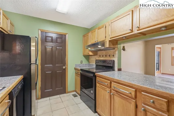 a kitchen with stainless steel appliances granite countertop a refrigerator and a stove top oven