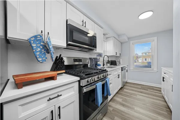 a kitchen with stainless steel appliances granite countertop a stove a sink and a microwave