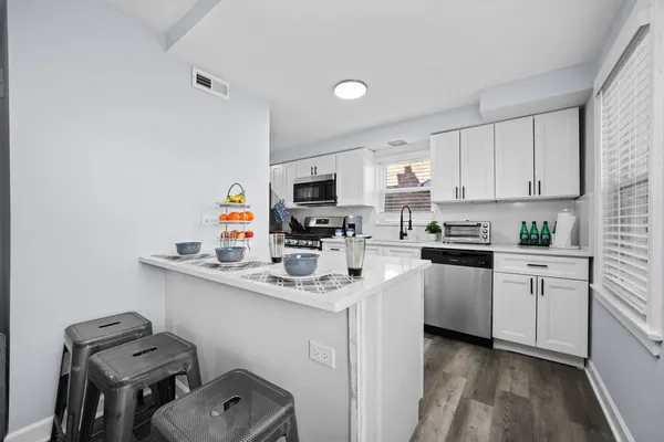 a kitchen with kitchen island a sink cabinets and appliances