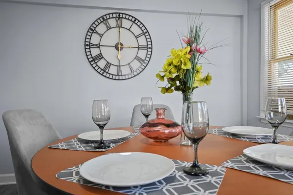 a dining room with furniture potted plants and wooden floor