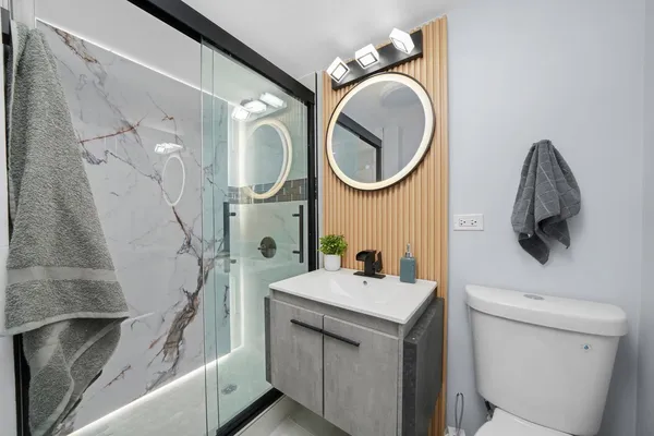 a bathroom with a sink a toilet and a mirror