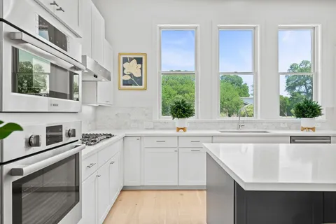 a kitchen with stainless steel appliances a sink stove and cabinets