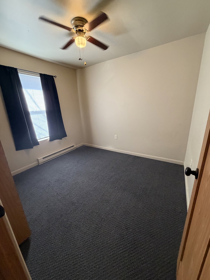 25731 West Bridge Street, Unit 2 Channahon, IL 60410 - Photo 7 of 9 an empty room with windows and fan