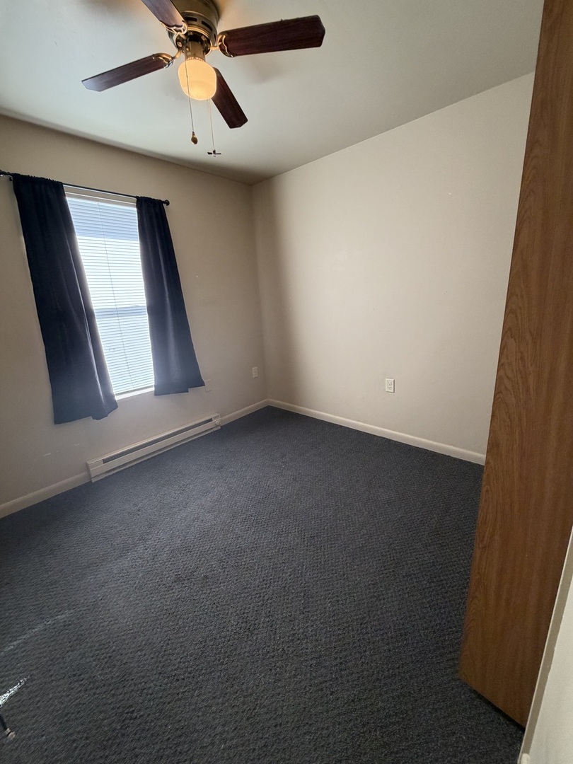 25731 West Bridge Street, Unit 2 Channahon, IL 60410 - Photo 9 of 9 an empty room with a ceiling fan and window