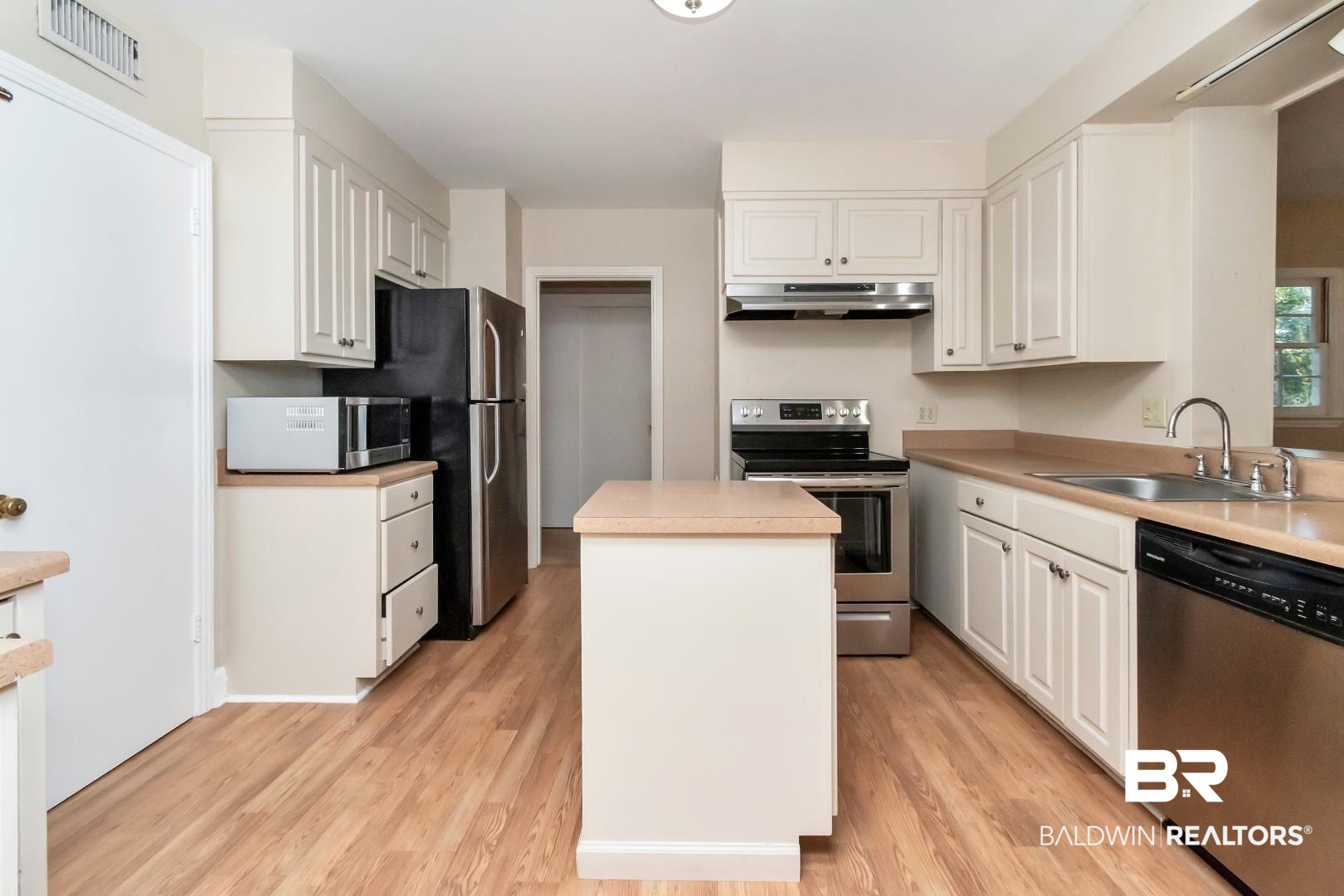 308 Brawood Drive Mobile, AL 36608 - Photo 13 of 33 Kitchen featuring white cabinetry, appliances with stainless steel finishes, light wood-type flooring, a kitchen island, and sink