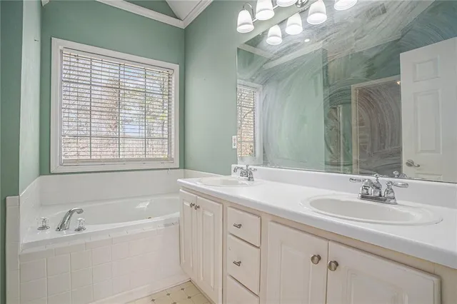 a bathroom with a tub a sink and mirror