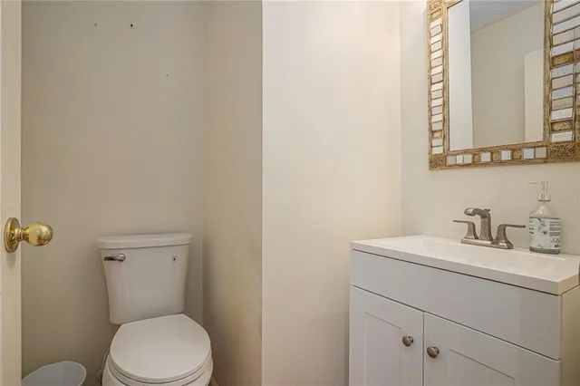 a bathroom with a toilet sink vanity and mirror