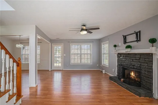 a living room with wooden floor and a fireplace