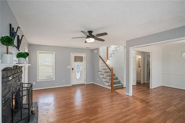 a view of empty room with wooden floor and ceiling fan