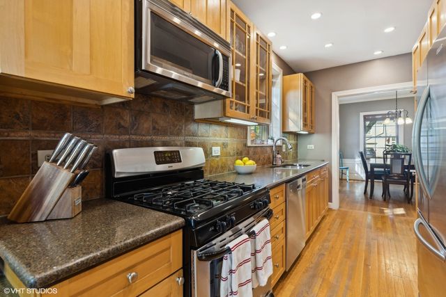 a kitchen with stainless steel appliances granite countertop a stove a sink and a microwave