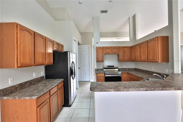 a kitchen with stainless steel appliances granite countertop a stove a refrigerator and a sink