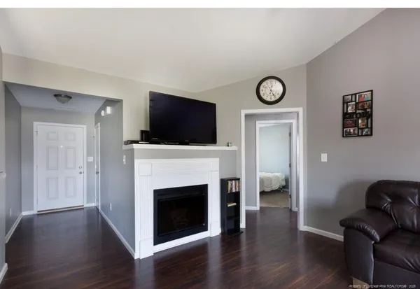 a living room with furniture a fireplace and a flat screen tv