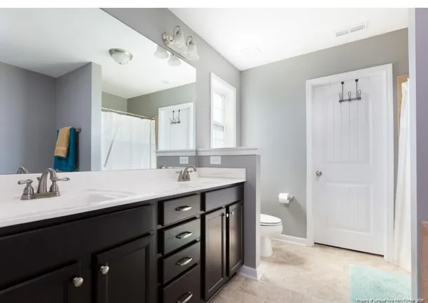 a bathroom with a double vanity sink toilet and mirror