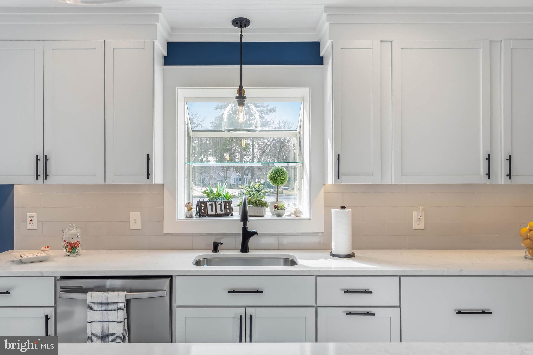 31394 Point Circle Lewes, DE 19958 - Photo 37 of 79 a kitchen with stainless steel appliances a sink a stove and white cabinets next to a window
