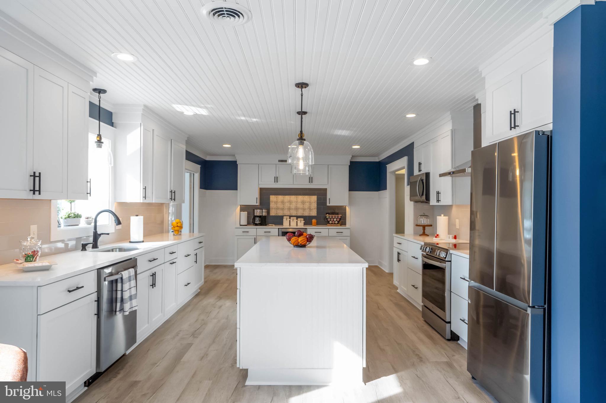 31394 Point Circle Lewes, DE 19958 - Photo 39 of 79 a kitchen view with stainless steel appliances a sink dishwasher a refrigerator and a stove with wooden floor
