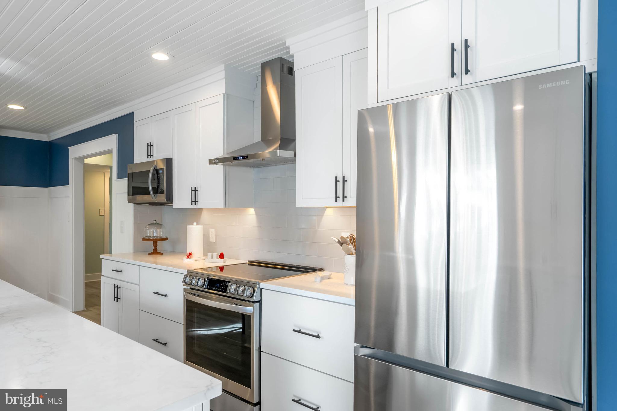 31394 Point Circle Lewes, DE 19958 - Photo 41 of 79 a kitchen with stainless steel appliances a refrigerator sink and white cabinets