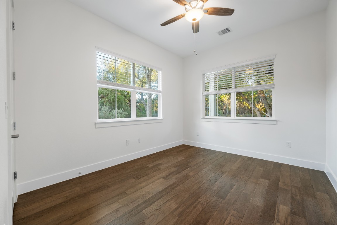 7906 Ryans Way Austin, TX 78726 - Photo 11 of 32 Downstairs bedroom with a closet and large windows for natural light. This is one of four bedrooms. It could also serve as an office or gym if needed.