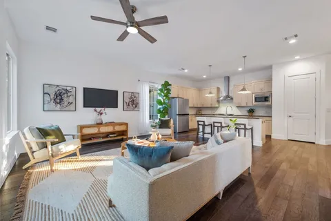 a living room with furniture floor to ceiling window and wooden floor