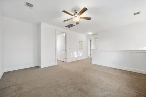 an empty room with a window and a fan