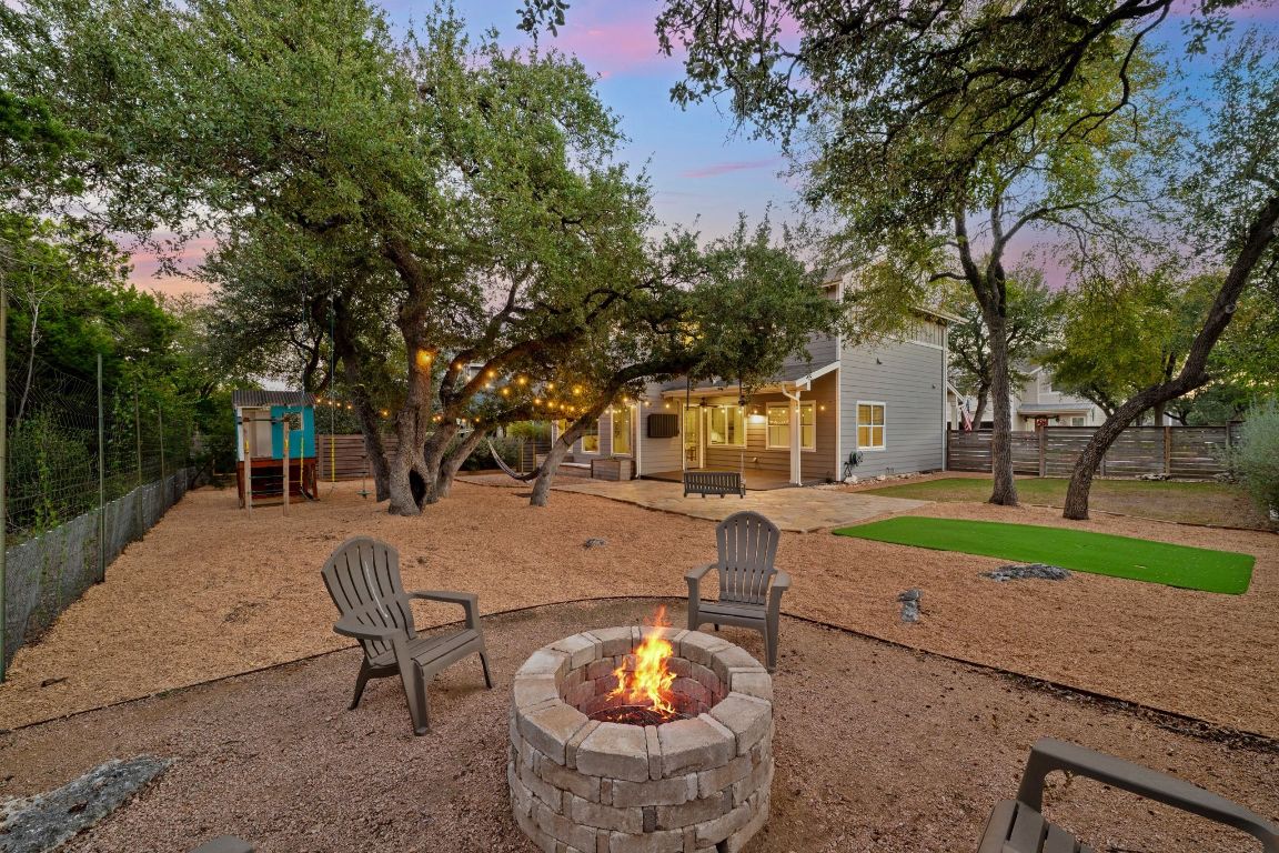 7906 Ryans Way Austin, TX 78726 - Photo 5 of 32 The backyard is spacious and offers plenty of room for running dogs or playing. It offers a fire pit, large trees for shade, and a covered patio for year round living.