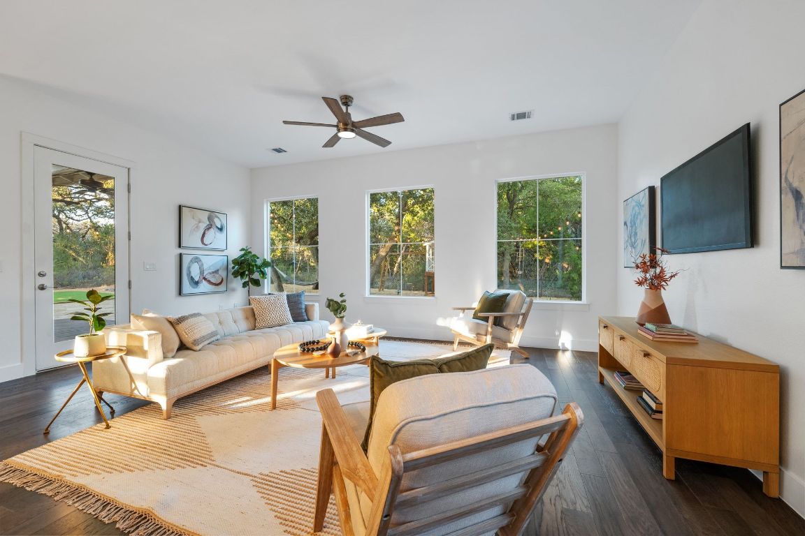 7906 Ryans Way Austin, TX 78726 - Photo 6 of 32 The living room has lot of natural light and plenty of living space with gorgeous wood floors.