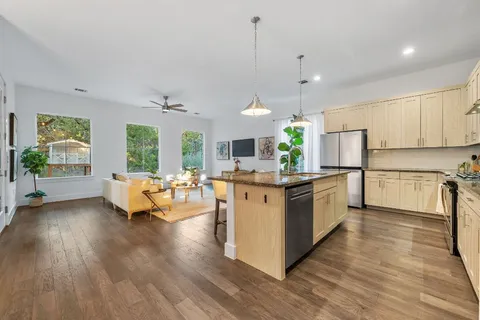 a large kitchen with granite countertop a sink and white cabinets
