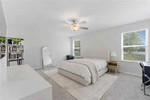 a bedroom with bed and a large window