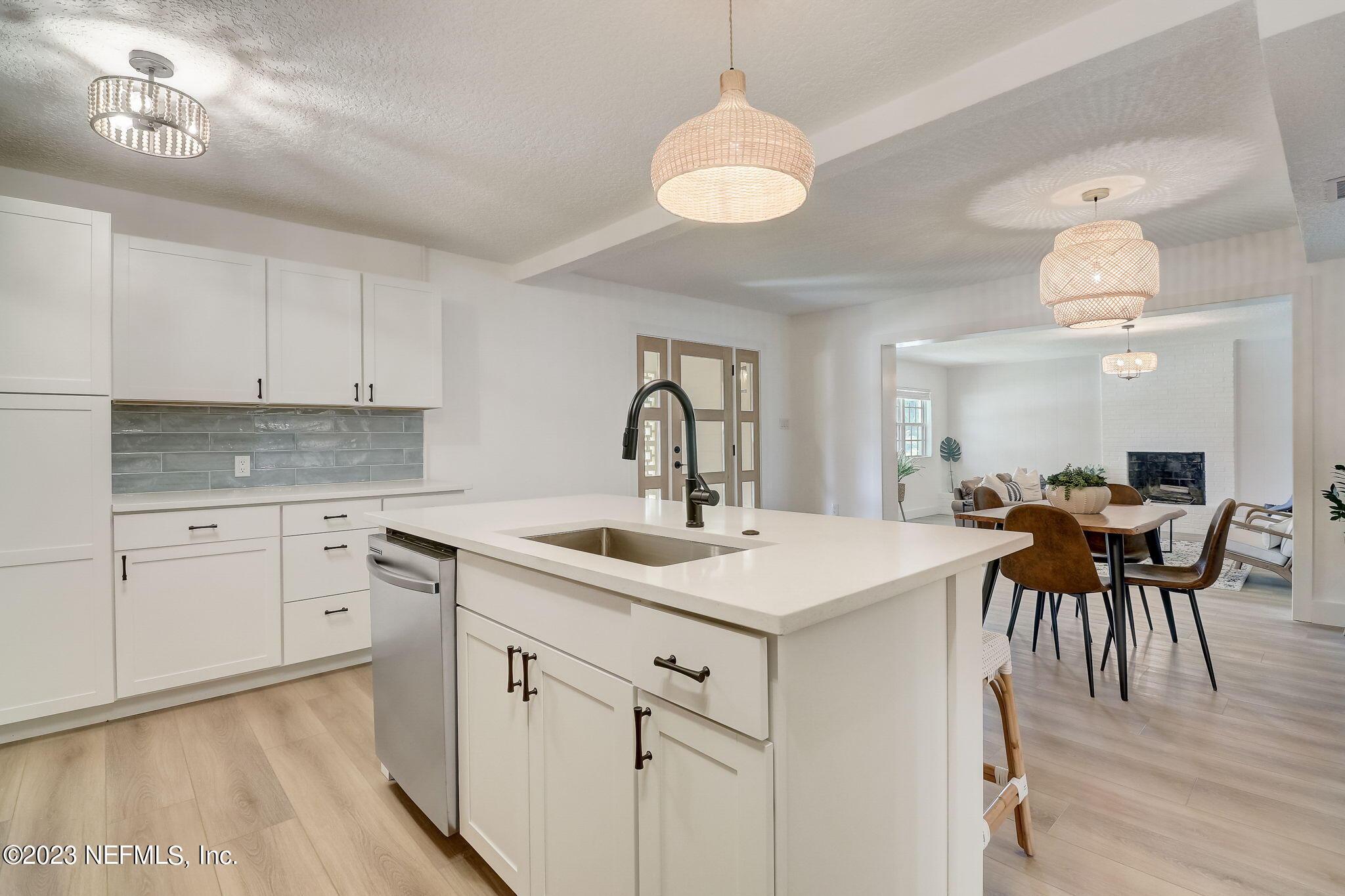 1706 Sunset Drive Jacksonville Beach, FL 32250 - Photo 12 of 44 a kitchen with a sink dishwasher a dining table and chairs with wooden floor