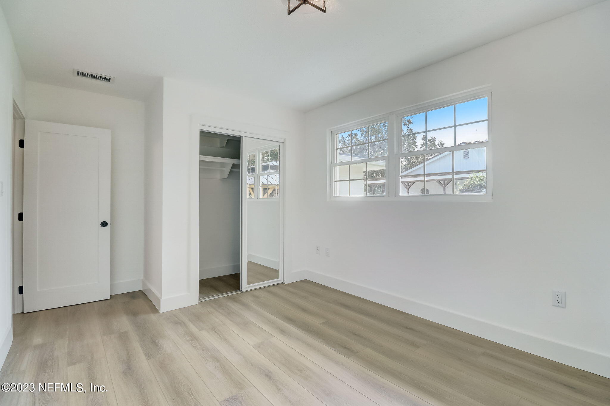 1706 Sunset Drive Jacksonville Beach, FL 32250 - Photo 23 of 44 a view of an empty room with wooden floor and a window