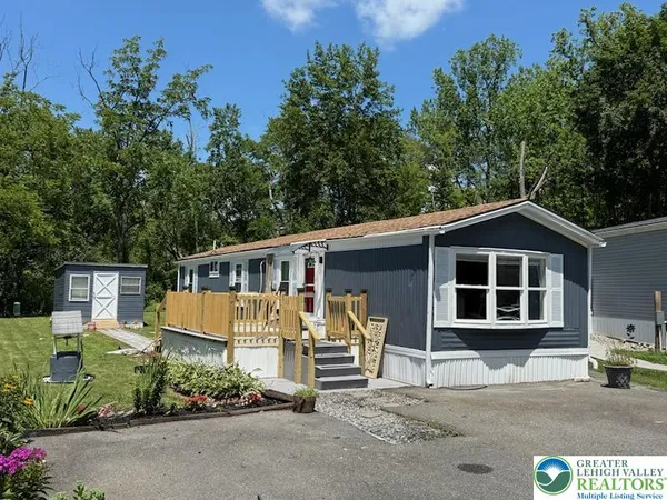 a view of a house with a yard and potted plants