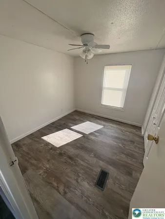 an empty room with wooden floor and stairs
