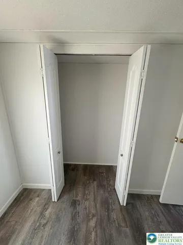 an empty room with wooden floor and stairs